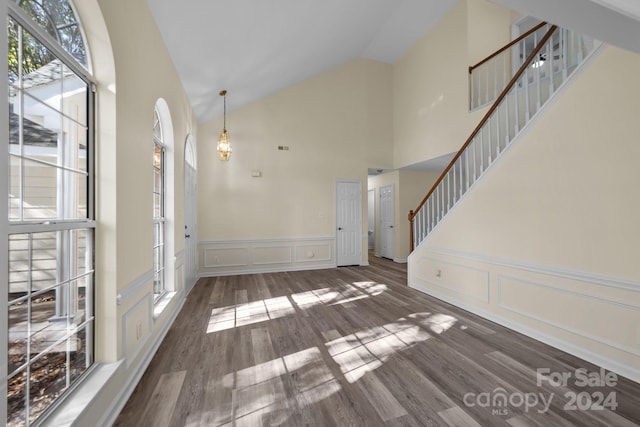 unfurnished living room featuring dark hardwood / wood-style floors and high vaulted ceiling