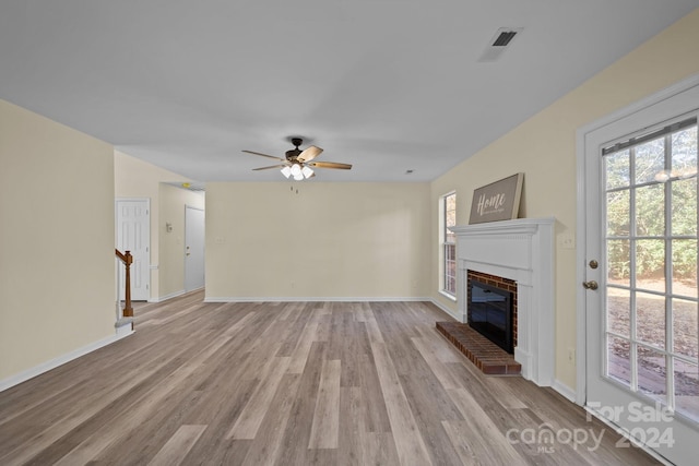 unfurnished living room featuring ceiling fan, light wood-type flooring, and a fireplace