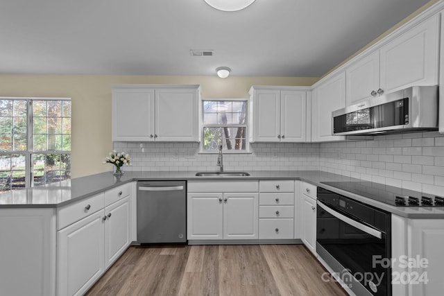 kitchen with kitchen peninsula, appliances with stainless steel finishes, plenty of natural light, and sink