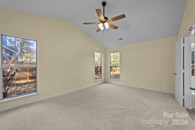 empty room with ceiling fan, light colored carpet, and lofted ceiling