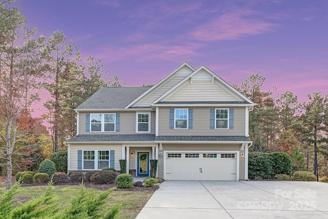 craftsman inspired home featuring a shingled roof, a garage, and driveway