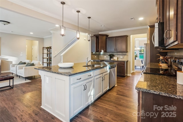 kitchen featuring a sink, appliances with stainless steel finishes, dark stone counters, and dark wood-style flooring