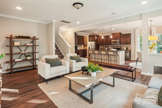 living room with dark wood-style flooring, baseboards, ornamental molding, recessed lighting, and visible vents