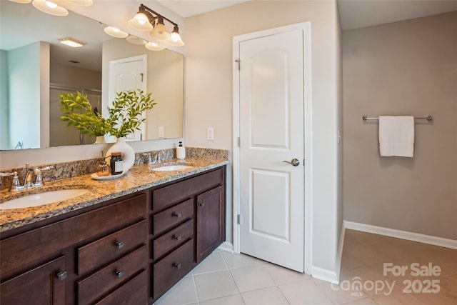full bathroom with a sink, tile patterned floors, double vanity, and baseboards