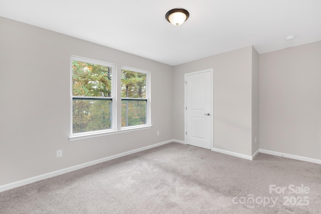 carpeted spare room with baseboards
