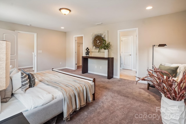 carpeted bedroom with baseboards, a walk in closet, and recessed lighting