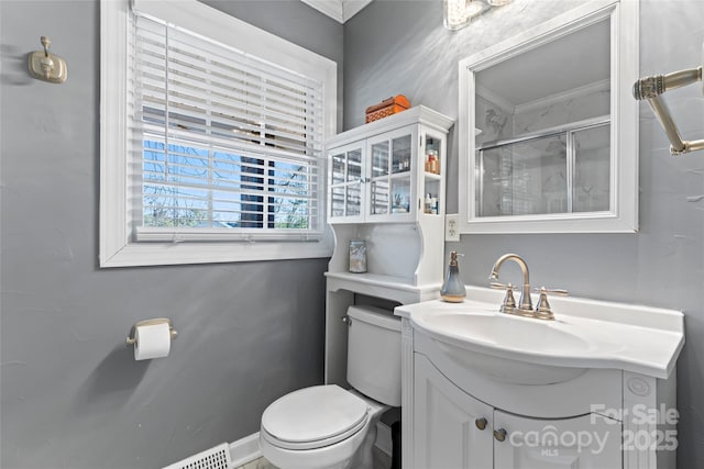 bathroom featuring toilet, a shower with door, and vanity