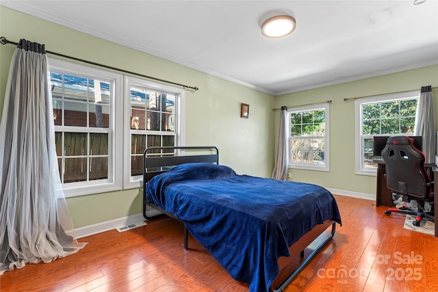 bedroom with wood-type flooring and crown molding