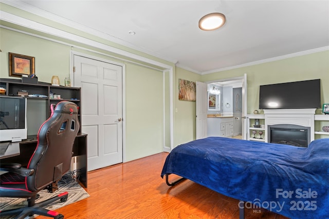 bedroom with ensuite bath, crown molding, and hardwood / wood-style floors