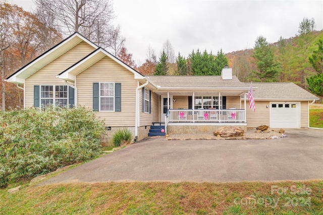 single story home featuring a porch and a garage