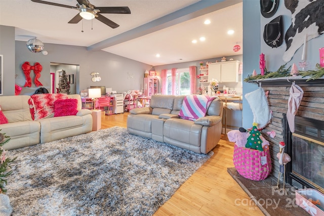 living room with light hardwood / wood-style floors, beamed ceiling, and ceiling fan