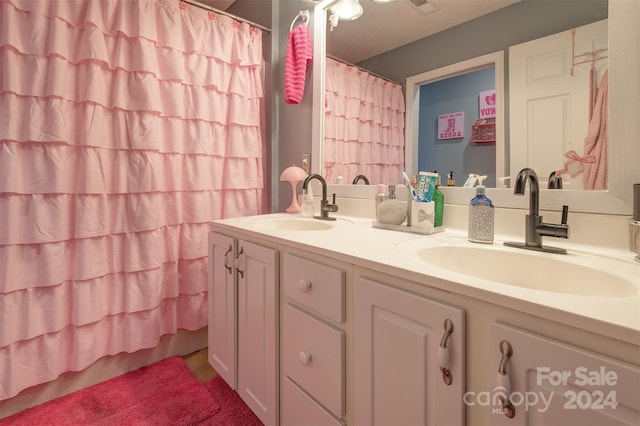 bathroom featuring a shower with curtain, vanity, and a textured ceiling