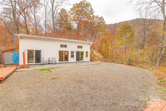 rear view of property featuring a patio and a deck