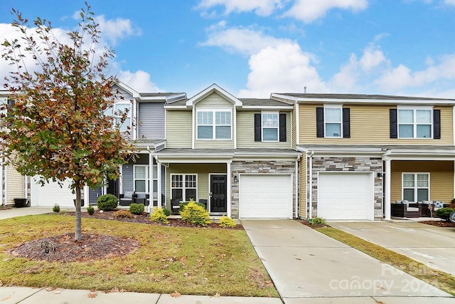 townhome / multi-family property featuring a front lawn and a garage