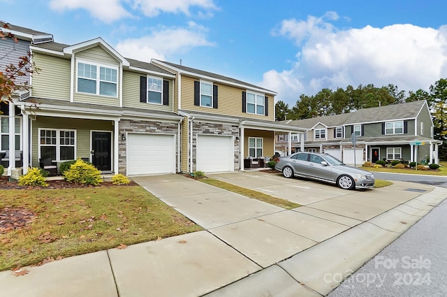 view of property featuring a garage and a front lawn