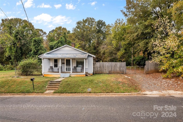 bungalow-style home with covered porch and a front yard