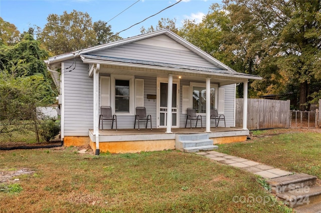 bungalow-style house with a front yard and covered porch