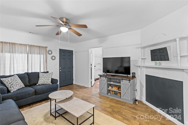 living room with light wood-type flooring and ceiling fan