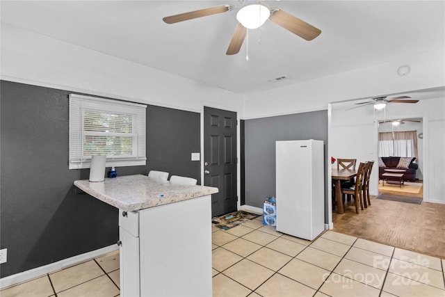 kitchen with light hardwood / wood-style flooring, ceiling fan, white fridge, and white cabinets