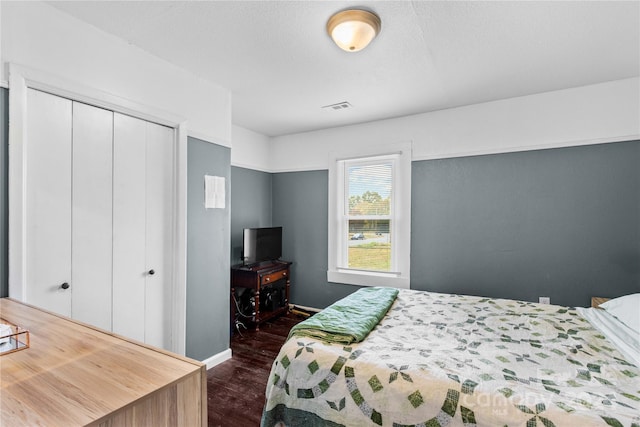 bedroom featuring a closet and dark hardwood / wood-style flooring