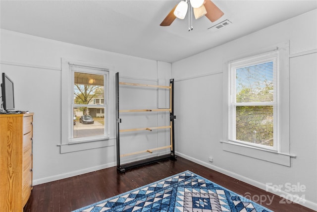 bedroom featuring multiple windows, dark hardwood / wood-style flooring, and ceiling fan