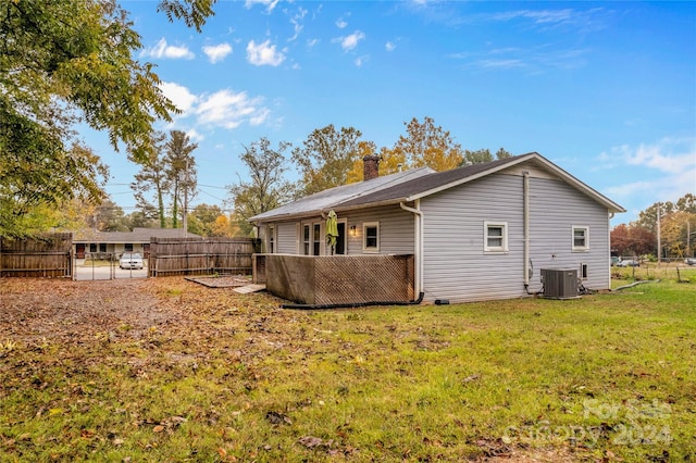 rear view of property featuring cooling unit and a yard