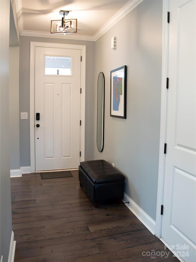 entryway featuring dark wood-type flooring, an inviting chandelier, and ornamental molding