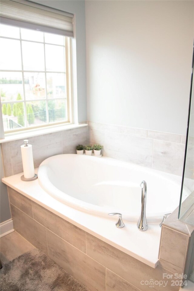 bathroom featuring a relaxing tiled tub