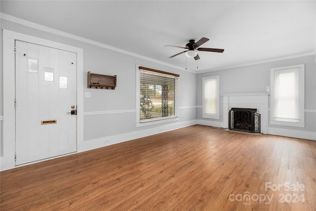 unfurnished living room featuring light hardwood / wood-style flooring, ceiling fan, ornamental molding, and plenty of natural light