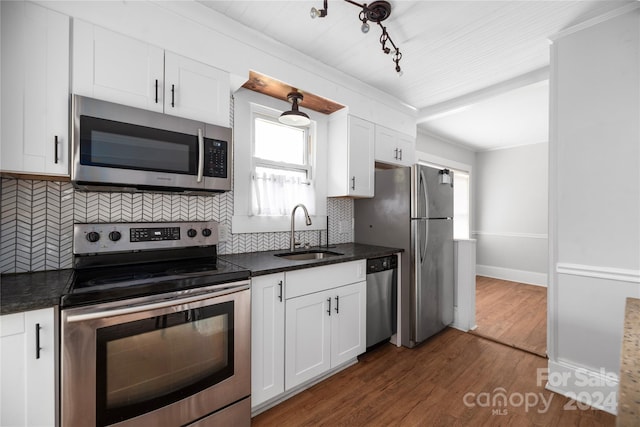 kitchen featuring tasteful backsplash, white cabinetry, appliances with stainless steel finishes, sink, and dark wood-type flooring