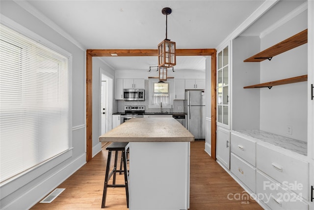 kitchen with stainless steel appliances, white cabinets, sink, and light wood-type flooring