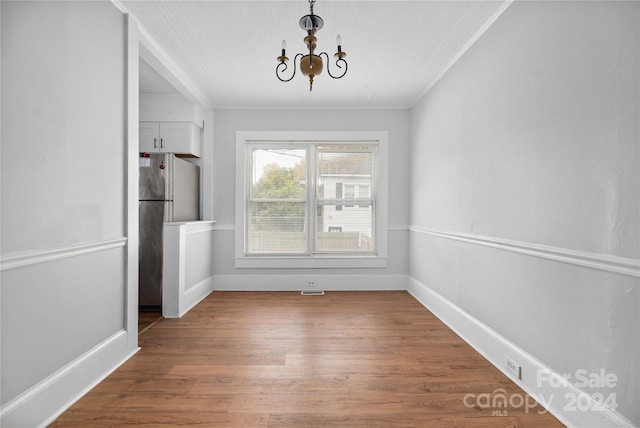 unfurnished dining area with wood-type flooring and crown molding