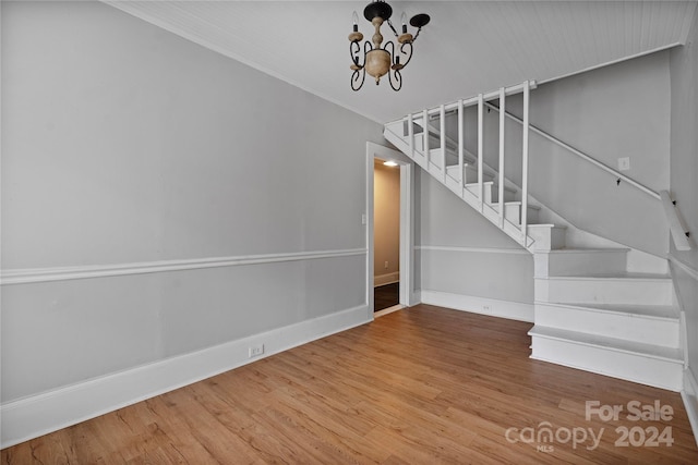 staircase featuring wood-type flooring and a notable chandelier