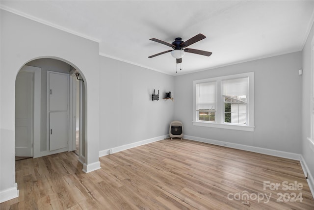 empty room with ornamental molding, light hardwood / wood-style flooring, ceiling fan, and heating unit