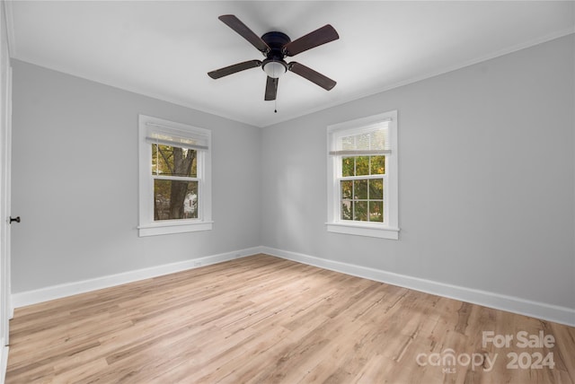 spare room with ornamental molding, ceiling fan, a wealth of natural light, and light hardwood / wood-style floors