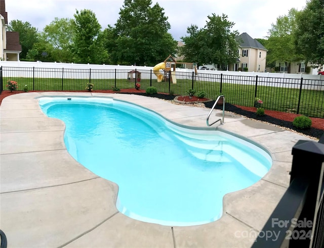 view of pool with a lawn