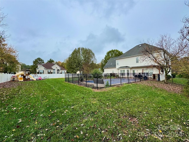 view of yard with a fenced in pool and a playground