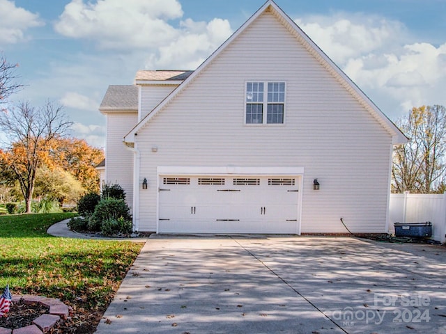 view of property exterior featuring a garage and a yard