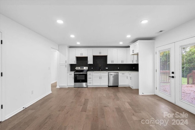 kitchen featuring stainless steel appliances, white cabinetry, light wood-type flooring, and french doors