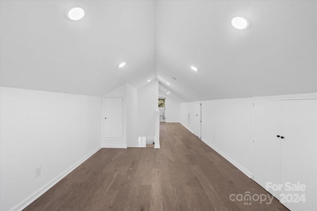 additional living space with dark hardwood / wood-style floors and lofted ceiling