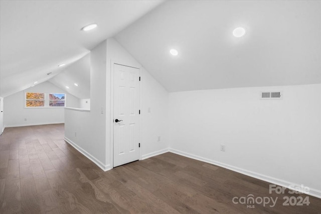 bonus room featuring dark wood-type flooring and vaulted ceiling