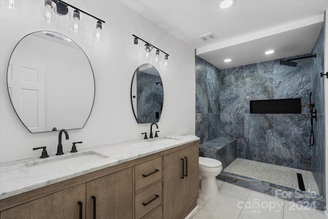 bathroom featuring vanity, toilet, and tiled shower