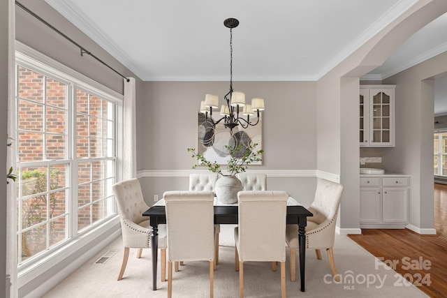 dining room featuring carpet flooring, a chandelier, and ornamental molding