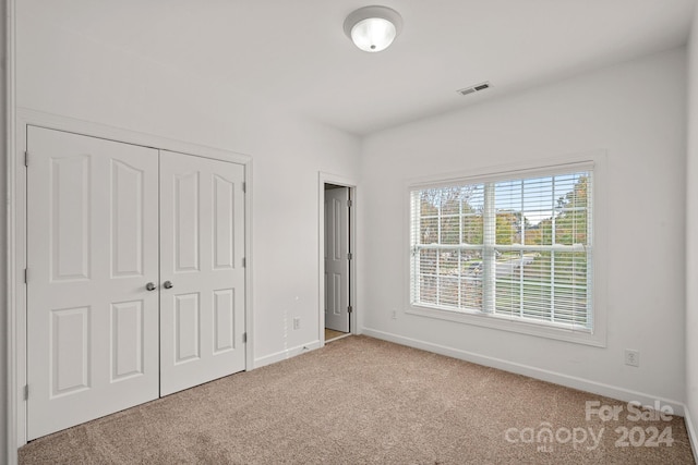 unfurnished bedroom with carpet and a closet