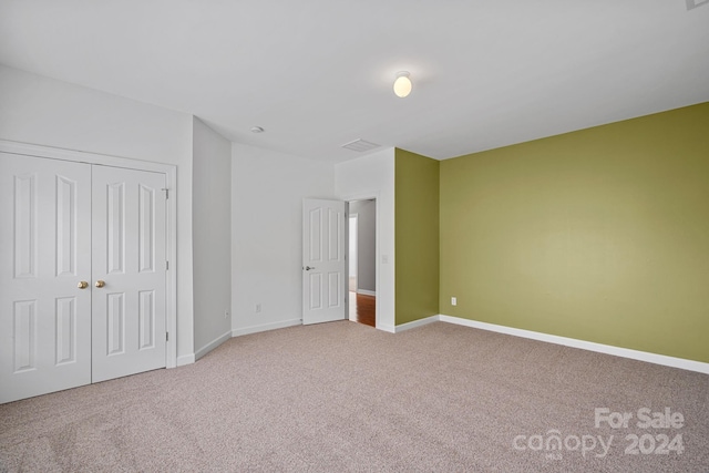 unfurnished bedroom featuring carpet floors and a closet