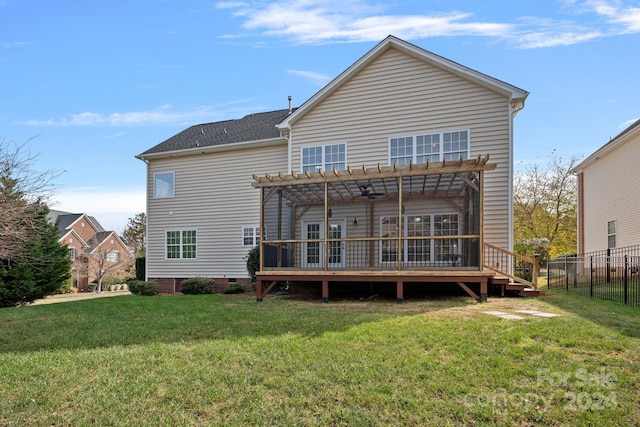 back of house with a pergola, a wooden deck, and a lawn