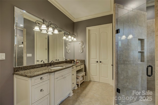 bathroom with a shower with shower door, vanity, tile patterned floors, and ornamental molding