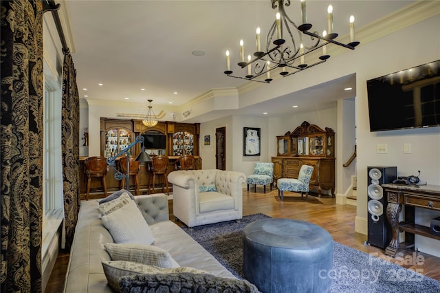 living room with bar, a chandelier, crown molding, and wood-type flooring