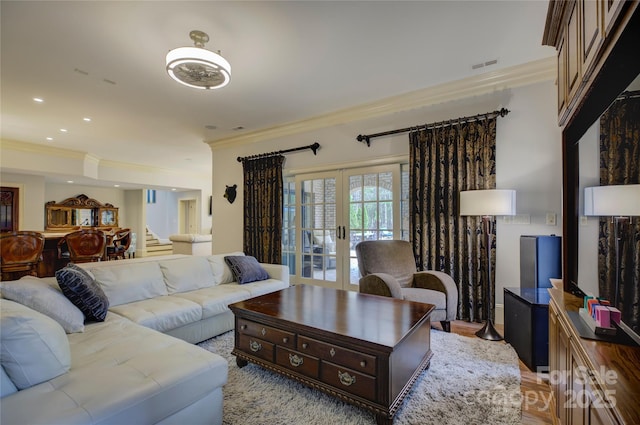 living room featuring ornamental molding, french doors, and light wood-type flooring