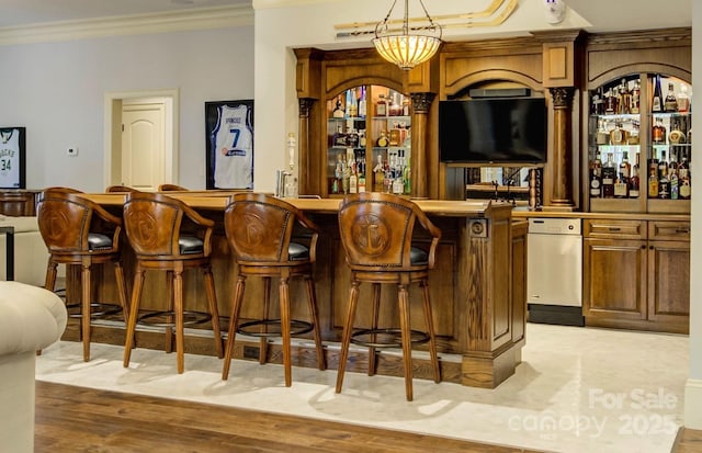 bar with ornamental molding and pendant lighting